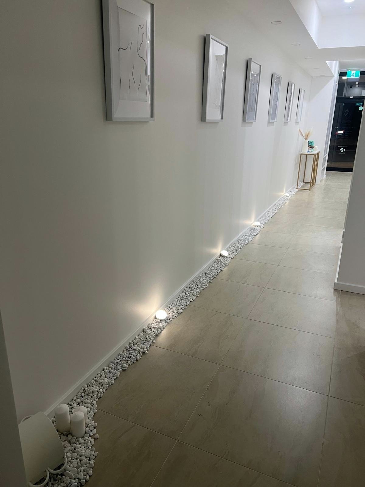 Eternity Laser clinic hallway with warm uplights and curated art in Dural